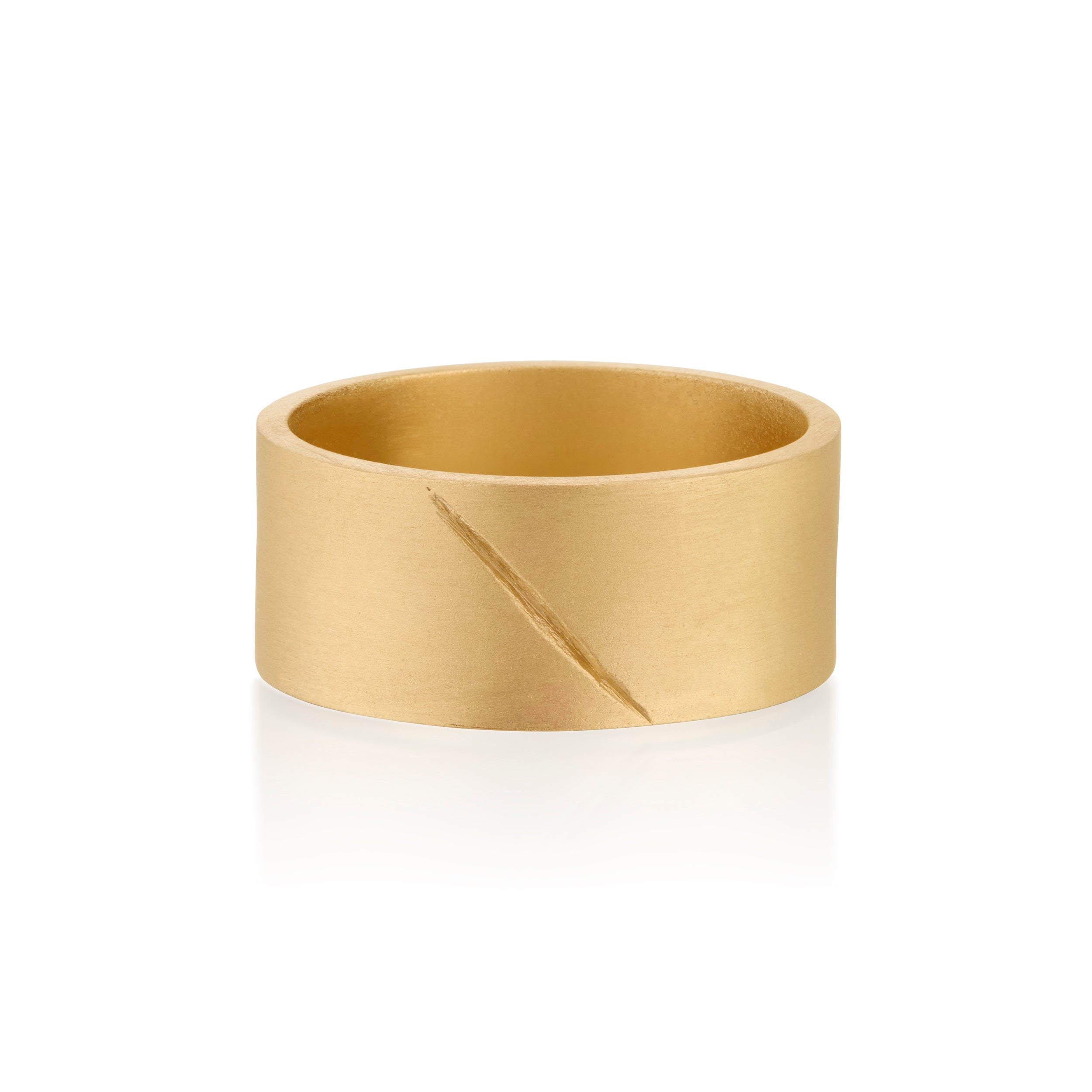 Gold band ring with an etched scar on a white background