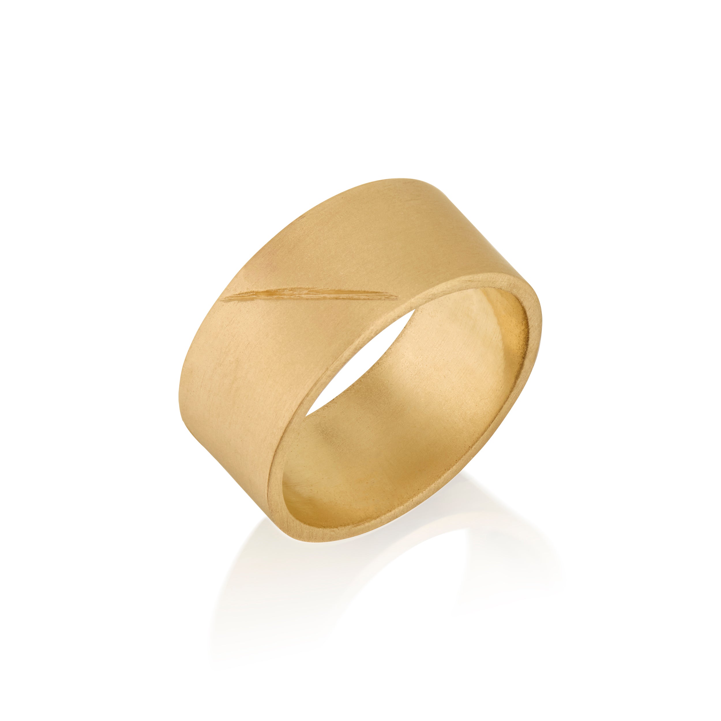 Gold band ring with an etched scar on a white background