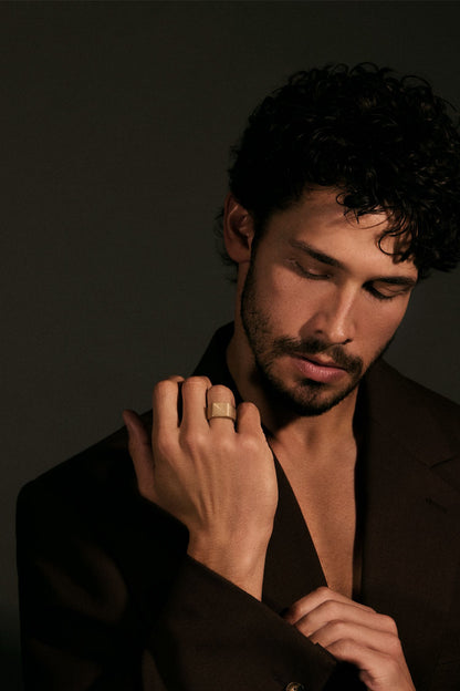 Man adjusting his jacket with a dark background