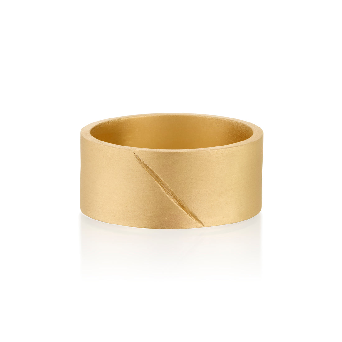 Gold band ring with an etched scar on a white background