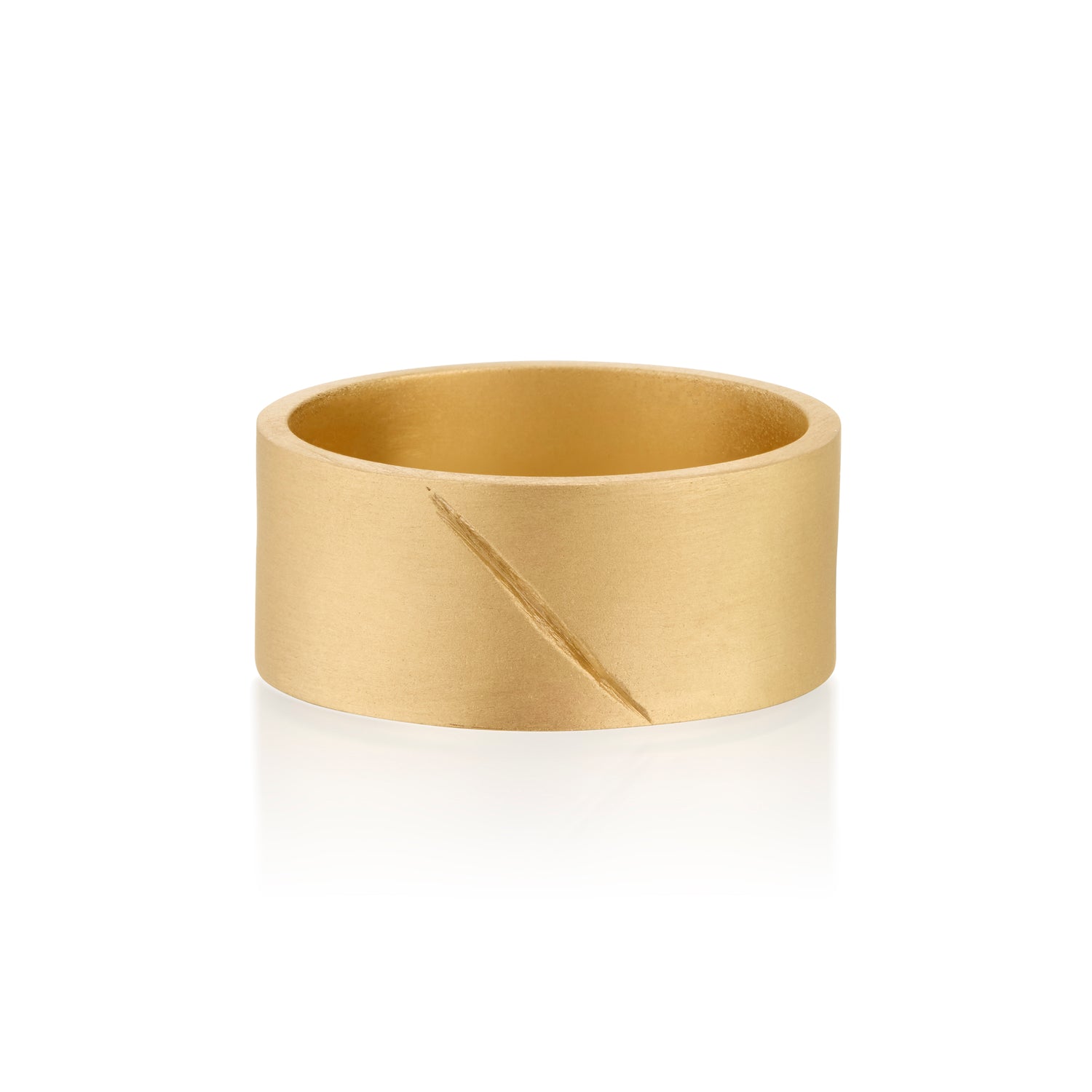 Gold band ring with an etched scar on a white background