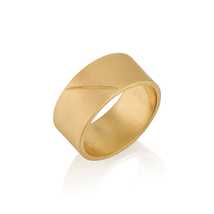 Gold band ring with an etched scar on a white background
