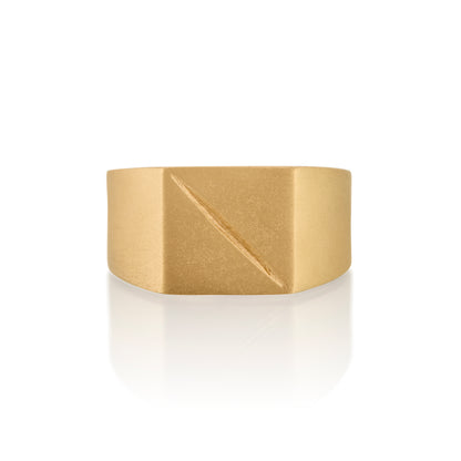 Gold ring 14k with a square face with an etched scar on a white background