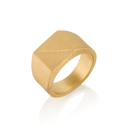 Gold ring 14k with a square face with an etched scar on a white background