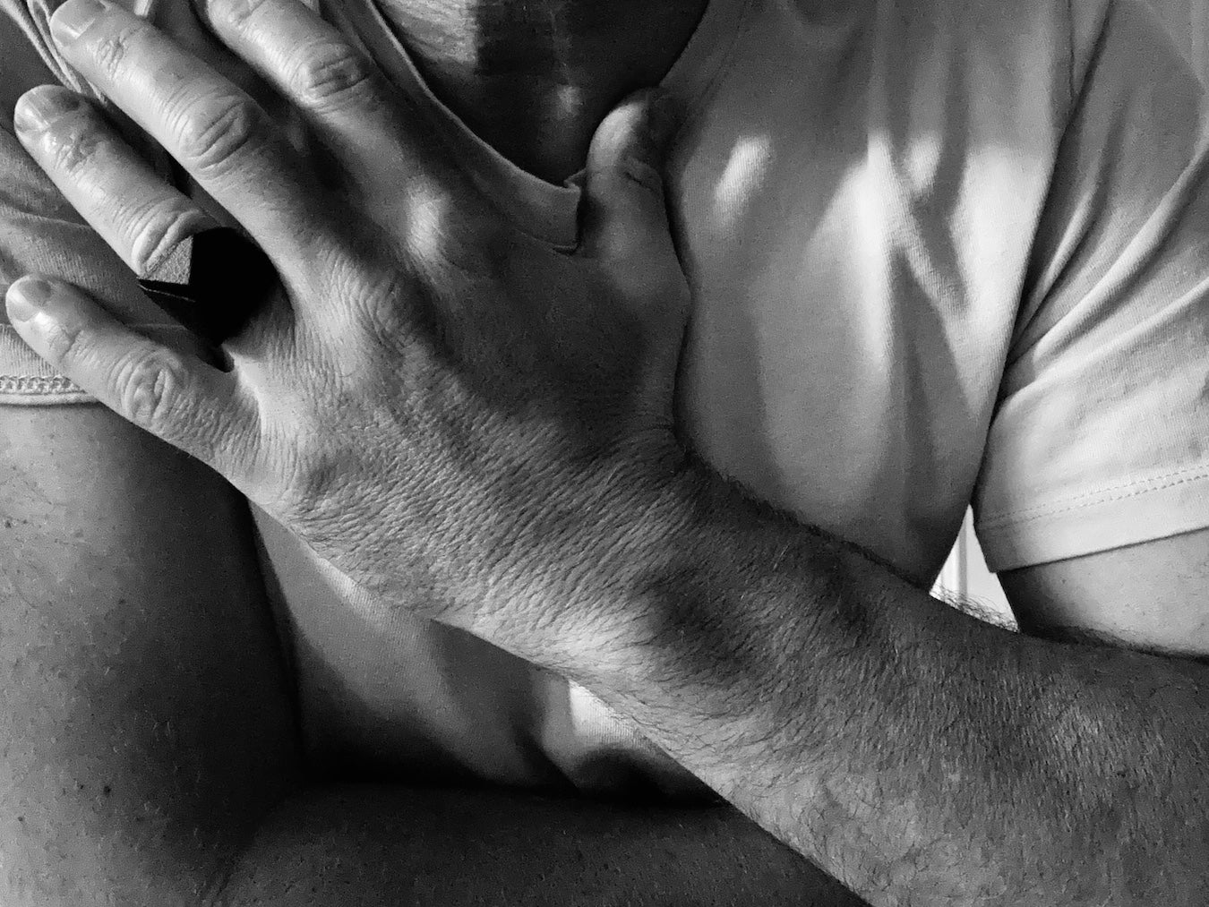 Person holding their chest with hands, modeling the new scar ring collection from MZNR men jewelry.